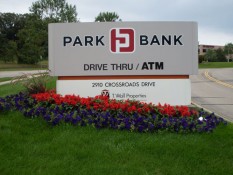 Flowers Beneath Park Bank Sign